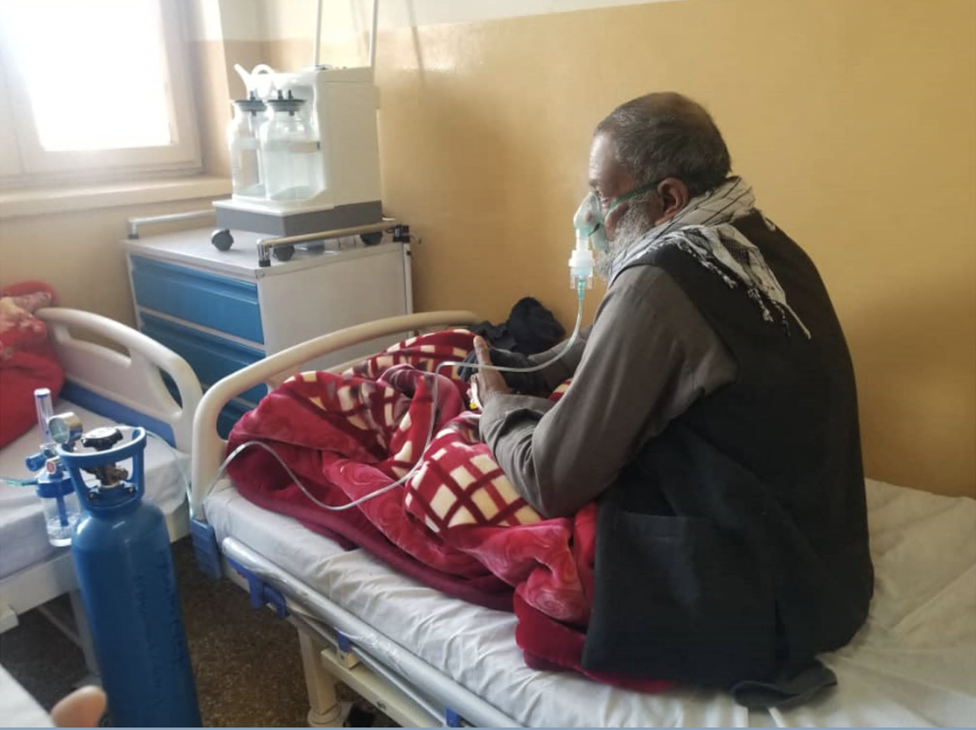 Afghan men sitting on a hospital bed