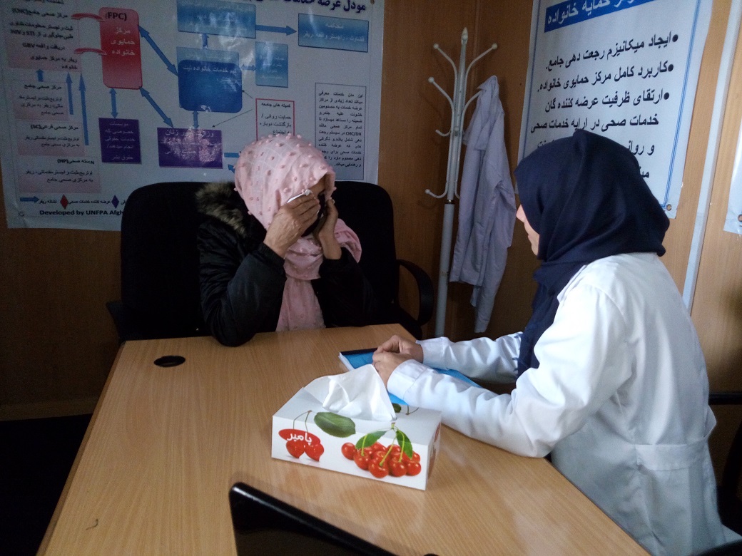 Afghan healthcare worker with a patient consulting