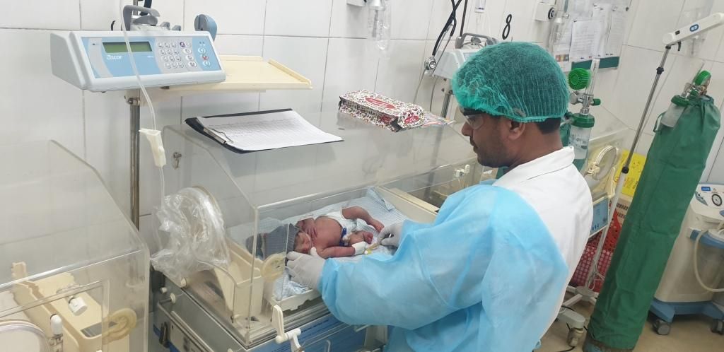 Afghan doctor holding a baby in the hospital