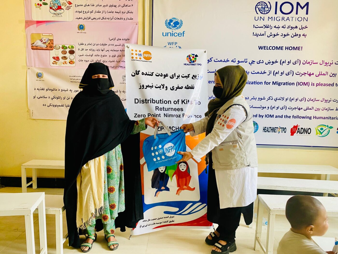 Early Childhood Educator distributing Mini Dignity kit in Nimruz zero point MCHC