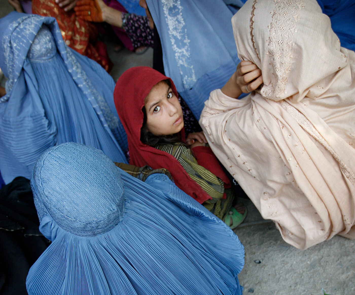 An Afghan girl surrounded by women looks back at the camera