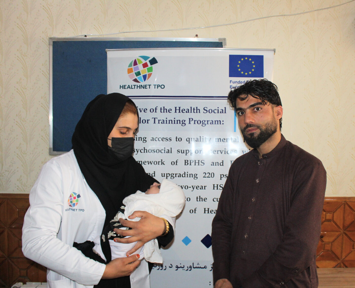 Afghan health social counsellor with her husband and newborn