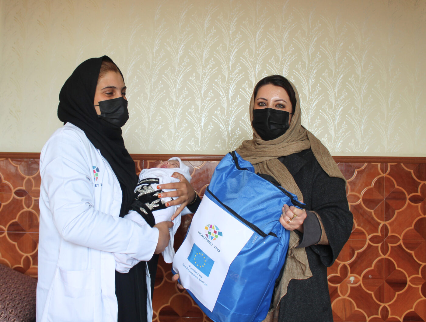 Afghan health social counsellor with her newborn baby and a colleague