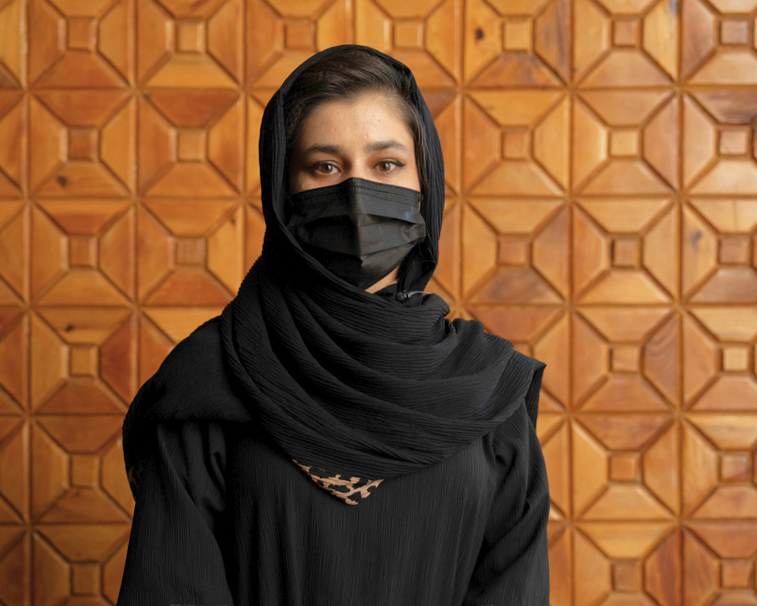 An Afghan woman wearing black clothes looks at the camera